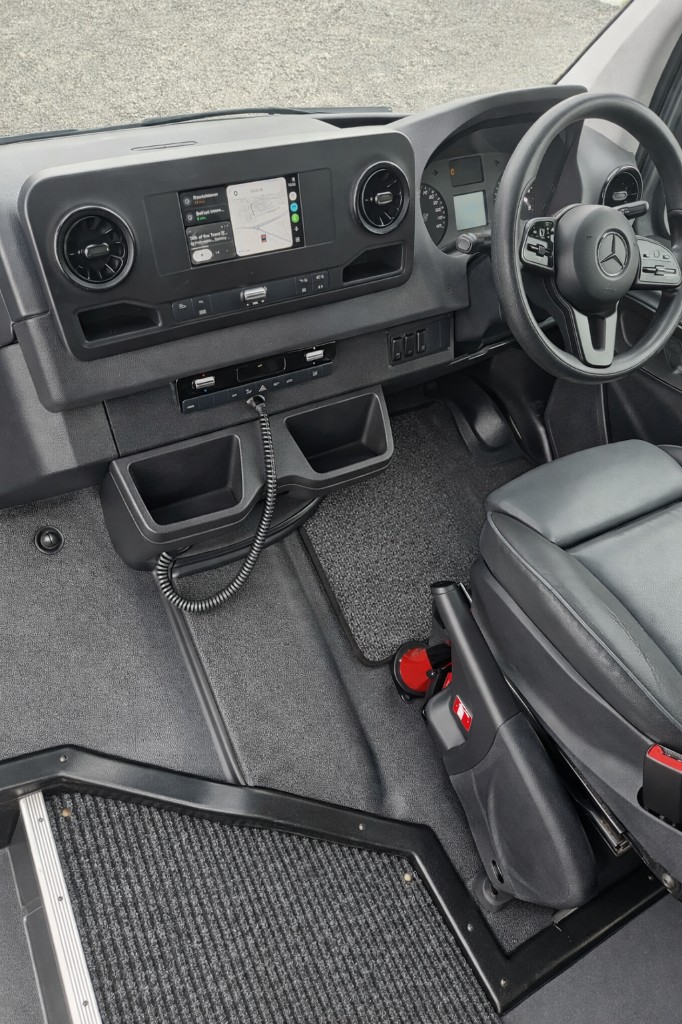 Driver cabin of Ace Cabs Mercedes 22-seater coach with modern dashboard and navigation