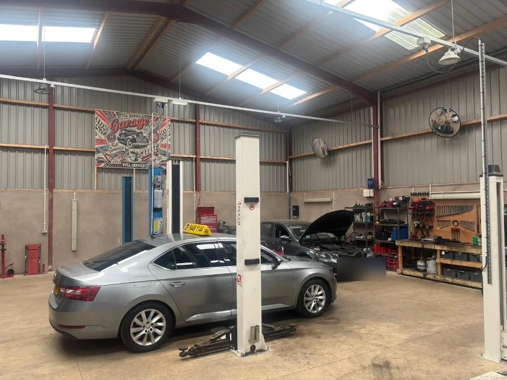 Ace Cabs taxi and saloon vehicles on professional two-post lifts in the company garage workshop