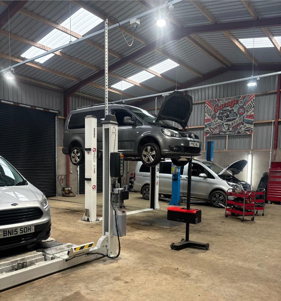 Ford Transit and Mercedes Vito fleet vehicles undergoing routine maintenance at Ace Cabs garage
