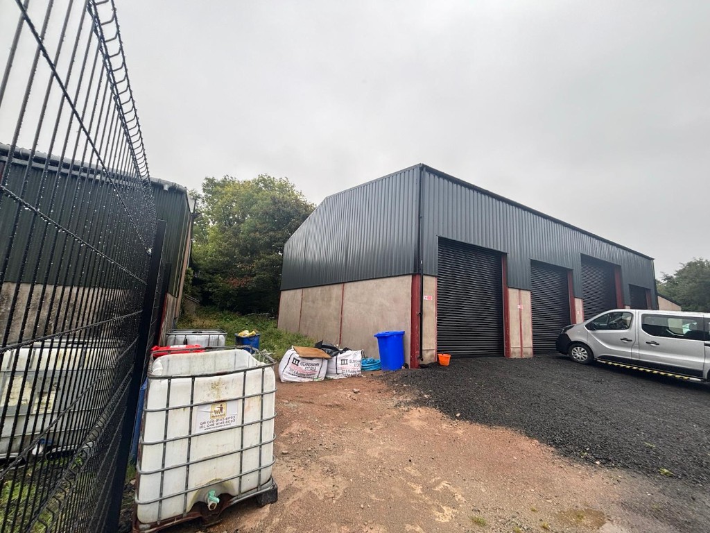 Four-bay Ace Cabs service centre building with fleet vehicles in the Antrim yard