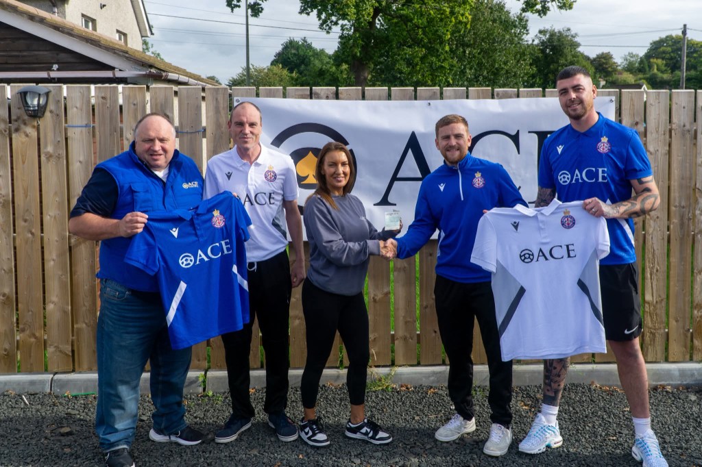 Ace Cabs team presenting sponsored Carniny AYFC football kits at kit handover with ACE banner