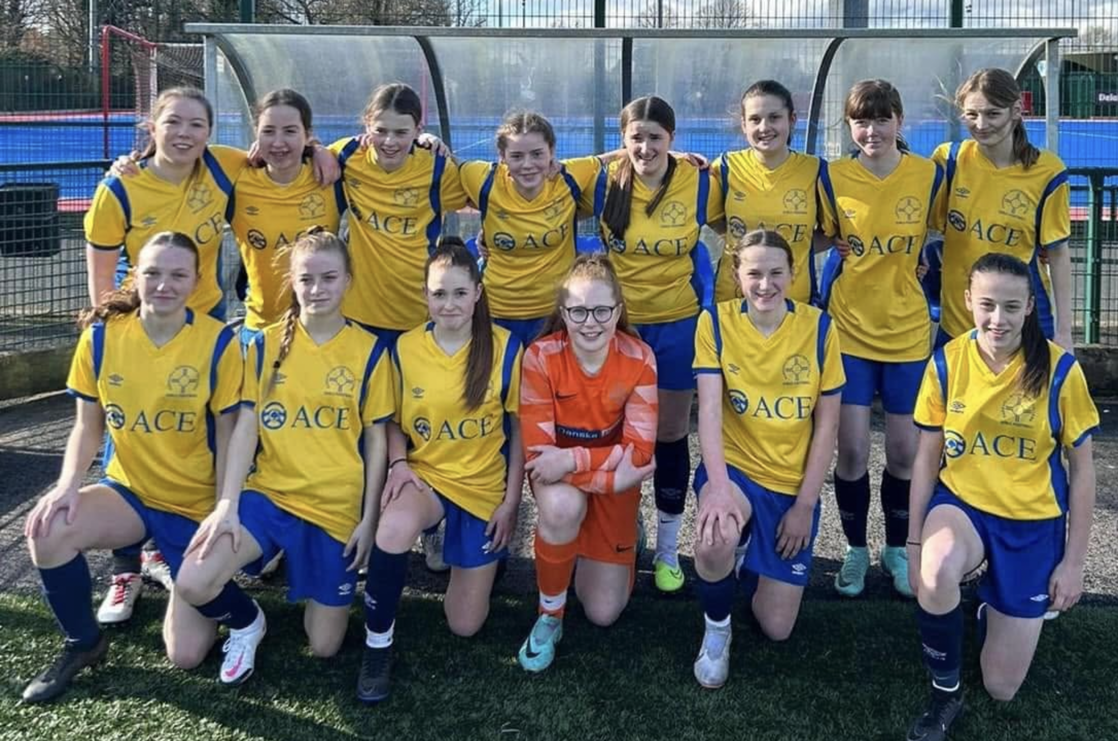 Parkhall Integrated College girls football team in Ace Cabs sponsored yellow kits